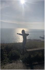 Livia's son jumping against a sunset over the sea